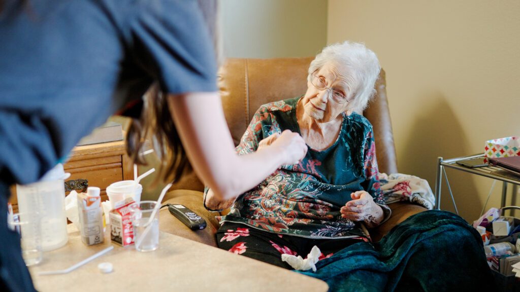 A long term care resident receives her dinner at a skilled nursing facility