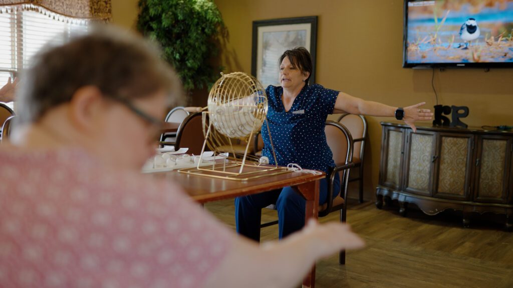 A nurse plays a bingo game with respite care patients at a skilled nursing facility