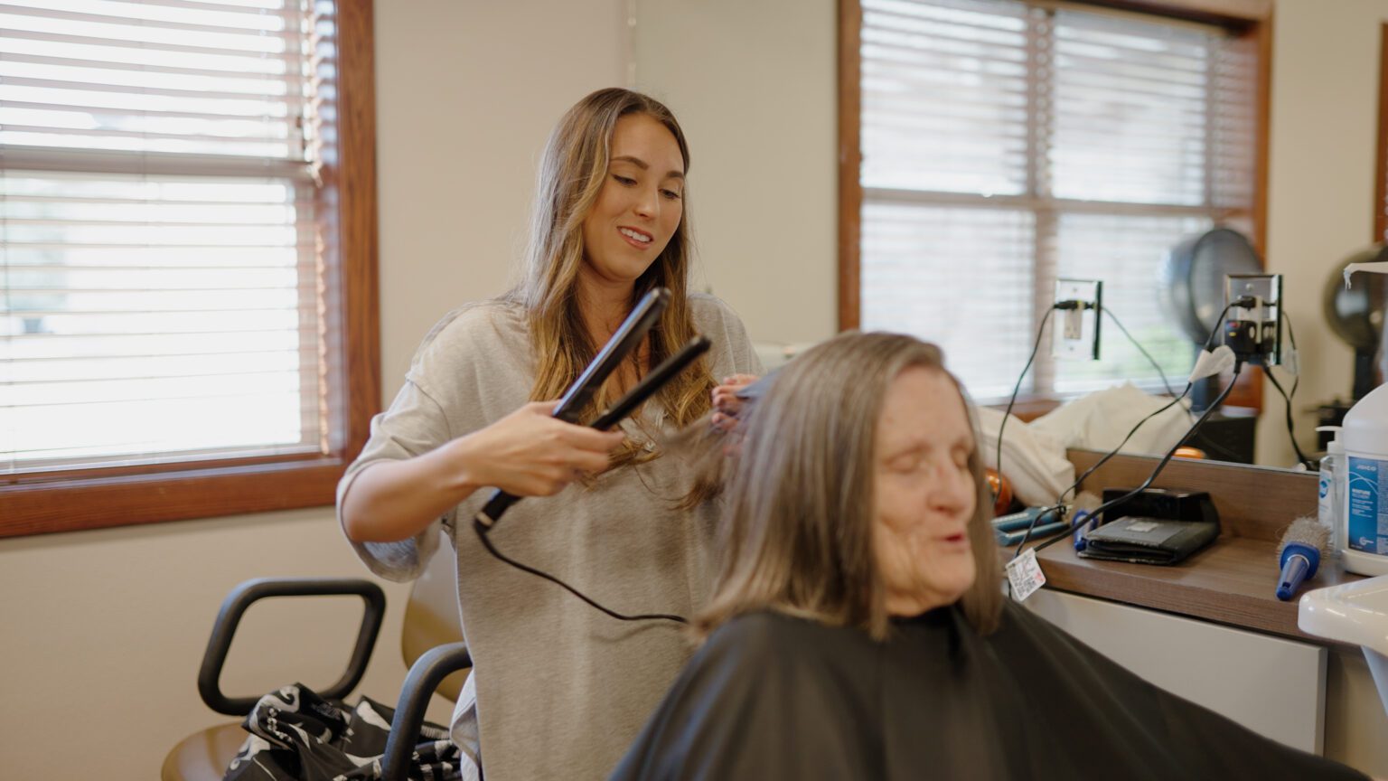 A woman getting her hair done by a stylist at Kathrine's Place a skilled nursing facility