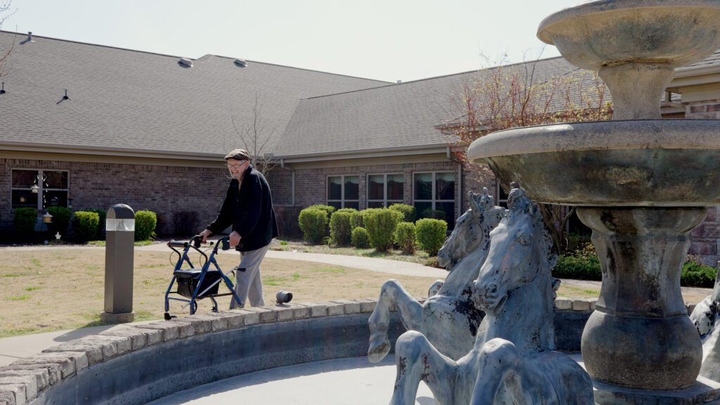 A man walks around a fountain at a skilled nursing nursing home available for long term care, short term care, and respite care residents